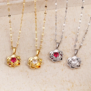 Detailed flat lay of rose pendant necklaces in gold and silver with red and clear crystals