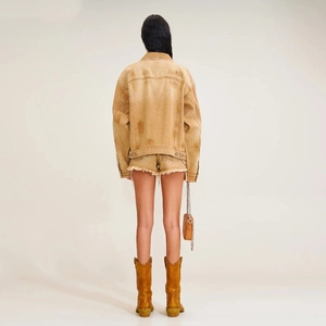 Back view of a tan denim jacket with matching frayed hem shorts and stylish leather boots