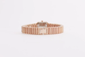 Detail of rose gold metal link strap and secure clasp on the square fashion watch