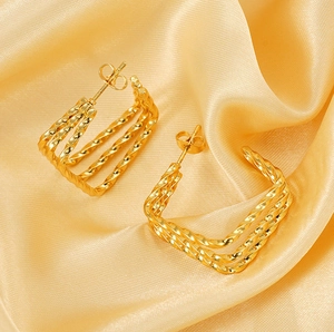 Detailed close-up of 18k gold-plated twisted triple-layer geometric hoop earrings