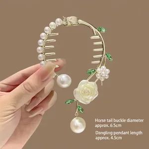 Détail de pince à cheveux muguet avec rose blanche, feuilles vertes et perle pendante