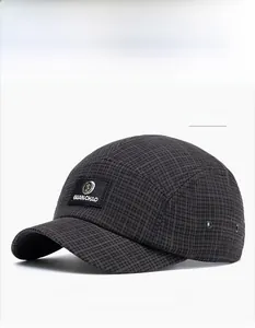 Close-up of dark grey plaid baseball cap showing metal logo and fabric texture