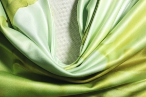 Gros plan détaillé du tissu imprimé floral brillant avec texture soie et dégradé de vert
