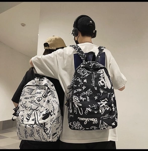 Detail of street graffiti canvas backpacks in black and white shown on models