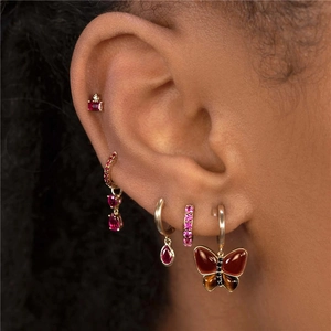 Close-up of S925 silver butterfly earrings and gold chain tassels with pink gemstones