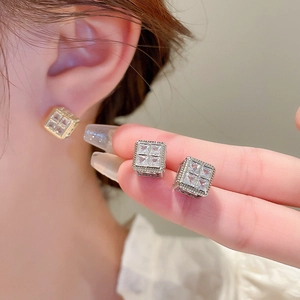 Macro shot of geometric square stud earrings featuring sparkling zircon pave in gold plating
