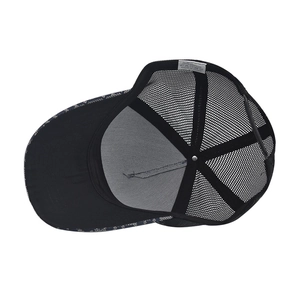 Detail view of black mesh trucker hat interior with 100% cotton tag and breathable fabric