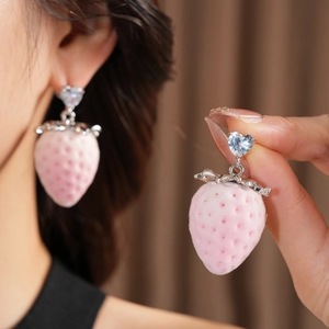 Detail of pink strawberry pendant earrings with heart zircon and velvet texture