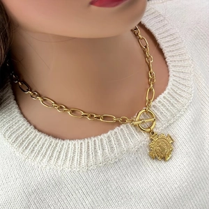 Macro detail of OT toggle clasp and vintage gold coin pendant on a chunky chain necklace