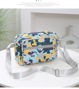 Detailed view of camo crossbody bag with multi-compartments and adjustable shoulder strap