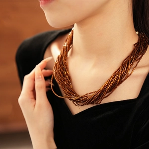 Dettaglio della collana multistrato di perline color bronzo con chiusura magnetica elegante