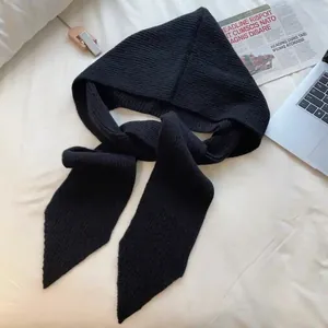 Close-up of black ribbed knit balaclava scarf with thick texture and cozy winter style