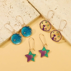 Detail of whimsical enamel galaxy earrings featuring cat, star and moon motifs