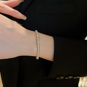 Close-up of gold-plated vintage cuff bracelet with zircon inlays on model's wrist