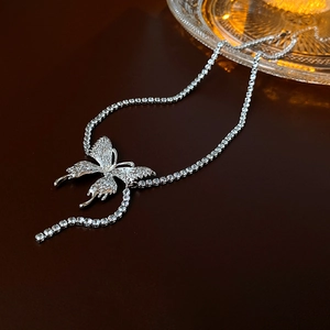 Detail of silver butterfly pendant with shimmering rhinestones on a tennis chain necklace