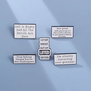 Set of 5 minimalist white enamel letter brooches with black quotes on light blue background