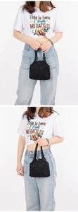 Detalle de bolso playero tejido negro con textura de nido de abeja y acentos esféricos 3D