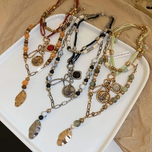 Detailed shot of bohemian multi-layered necklaces with butterfly coins and colorful beads
