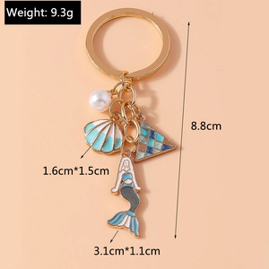 Detail view of mermaid keychain with blue shell, white pearl, and size dimensions