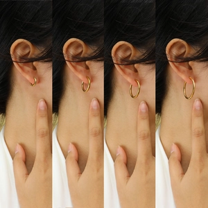 Minimalist gold hoop earrings in four different sizes shown on a model's ear