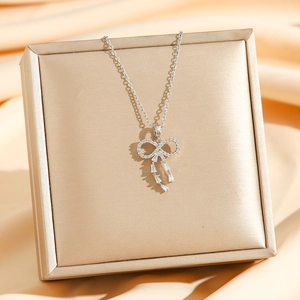 Sparkling bow-knot necklace with rhinestone tassels and baguette zircon on a silk background