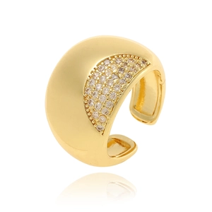 Macro shot of gold-plated wide ear cuff with crystal accents and sharp reflections