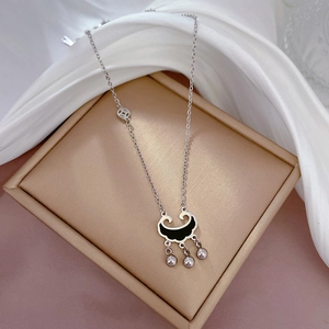 Macro shot of silver titanium steel lock necklace with black inlay on golden display box