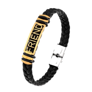 Detail of black braided leather bracelet with gold FRIEND engraved plaque and silver clasp