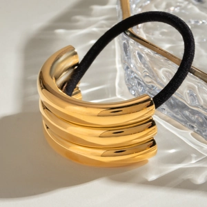 U-shaped gold metal hair cuff with black elastic tie on aesthetic water ripple glass