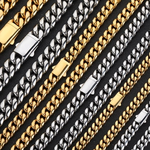 Détail de chaînes cubaines en or 18k et argent avec fermoir poli sur fond noir