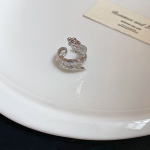 Macro detail of silver snake wrap ring with intricate scale texture and open design