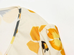 Close-up of yellow and orange floral print on ribbed texture fabric for women's top
