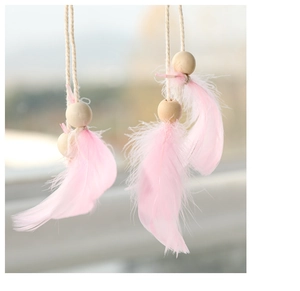 Detail of pink feather hanging ornament with natural wooden beads for Christmas decor