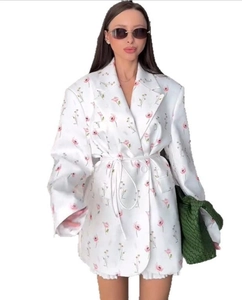 Détail du blazer blanc à imprimé floral avec ceinture et design élégant à revers