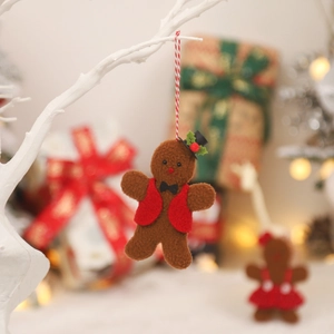 Festive gingerbread man felt ornament in suit and hat hanging on white branch