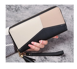Close-up of tricolor patchwork long wallet with tassel charm and wrist strap