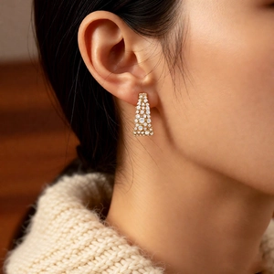 Gros plan de boucles d'oreilles en U plaquées or 18 carats avec zircons sur un modèle