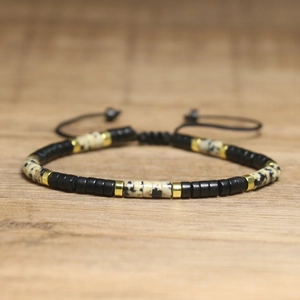 Detail view of woven beaded bracelet with imperial stone and adjustable black cord strap