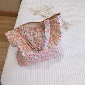 Vue détaillée d'un sac cabas en coton fleuri avec fermeture éclair et étiquette tissée