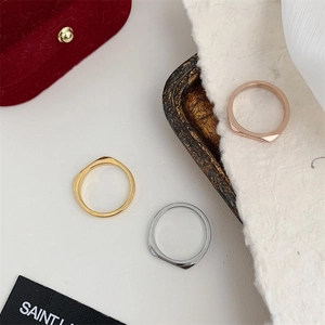 Close-up of geometric rings in gold, silver, and rose gold with faceted metal finish