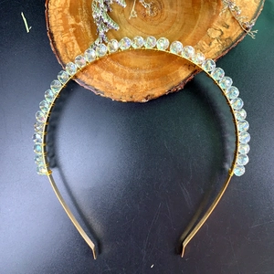 Detailaufnahme von goldenem Metall-Haarreif mit schimmernden irisierenden Kristallperlen