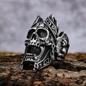Gothic skull ring with crown carving in stainless steel on a rustic wood background