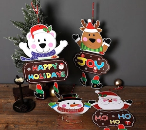 Detailed view of assorted Christmas paper pendants with Santa and Reindeer on a wooden table
