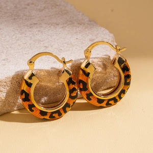Detail of 14k gold plated earrings featuring orange leopard print enamel on stone
