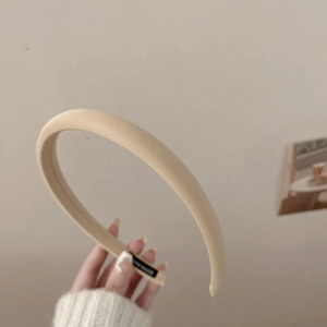 Détail d'un serre-tête beige fait main avec texture côtelée et étiquette tissée intérieure