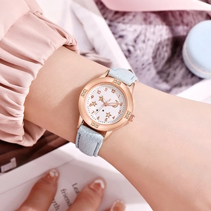 Gros plan d'une montre en or rose avec lunette en cristal et bracelet en cuir bleu clair