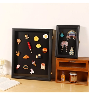 Detailed view of black shadow box frames displaying miniature figurines and magnetic art