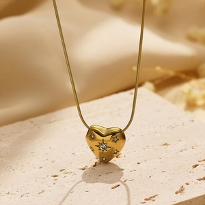 Golden heart pendant necklace with star engravings and zircon on a sleek snake chain