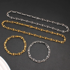 Modern gold and silver figure-eight chain necklace and bracelet jewelry set on black leather