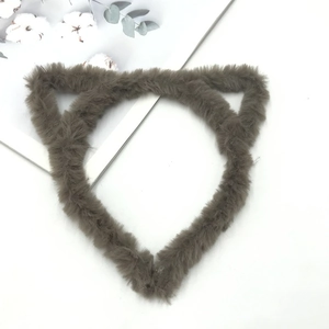 Detailed view of plush brown cat ear headband on white background with cotton decorative card